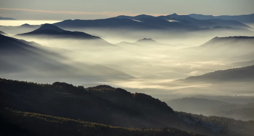 Bieszczady, panorama z Połoniny Wetlińskiej. W dole zanurzone we mgle Wołosate. W oddali rysują się szczyty ukraińskiego pasma Bieszczadów. Zdjęcie Radek Kaźmierczak Bieszczady Photography