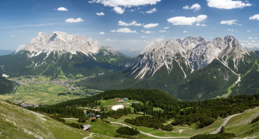Widok z kolejki linowej na Grubigstein w kierunku Zugspitze oraz na miasteczko Ehrwald. Zdjęcie Adobe Stock